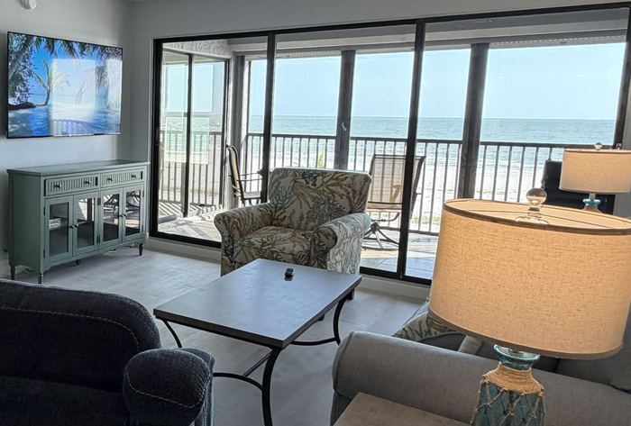 Living room seating with 65 inch smart TV and lanai beyond