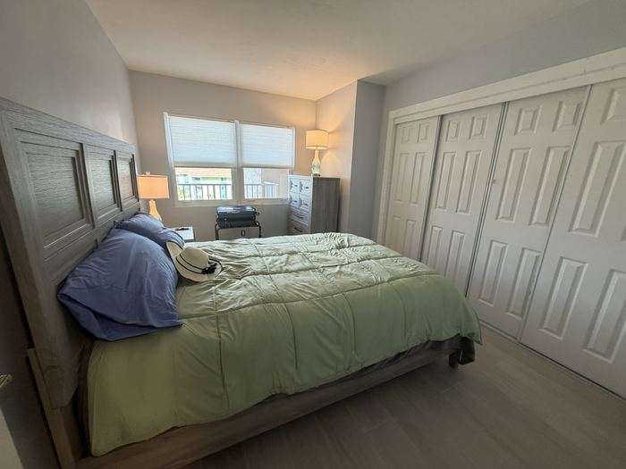 Guest bedroom with queen bed and wall of closet storage